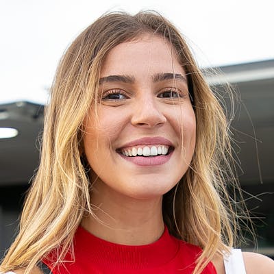 Jeune femme souriante, chemise profesionnelle et badge autour du coup