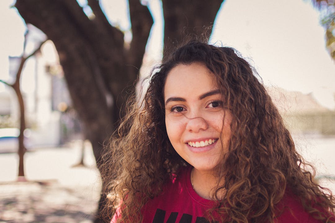 Jeune femme souriante, chemise profesionnelle et badge autour du coup