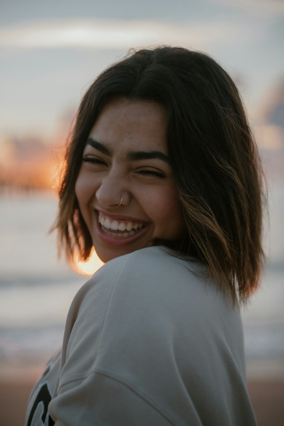 Jeune femme souriante, chemise profesionnelle et badge autour du coup