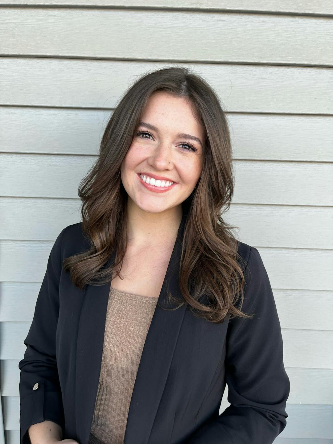 Jeune femme souriante, chemise profesionnelle et badge autour du coup