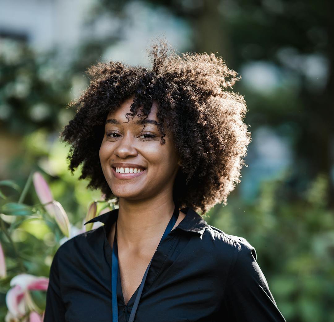 Jeune femme souriante, chemise profesionnelle et badge autour du coup